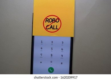 Robocall Write On A Sticky Note Isolated On Office Desk.