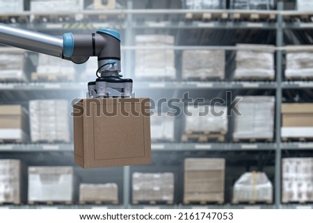 Robot arm moves boxes in an automatic warehouse. Concept