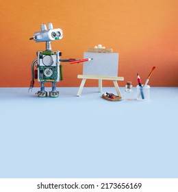 Robot artist begins to create a drawing with a pencil. White paper mockup, wooden easel and artist's tools palette, pencils case. Promotion poster mockup for art studio school. - Shutterstock ID 2173656169