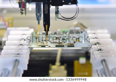 robot automatically assembles circuit board with electronic components in a modern factory