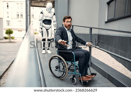 The robot was carrying a young businessman in a suit along a ramp near a building in a wheelchair when it malfunctioned and froze. The future with artificial intelligence.