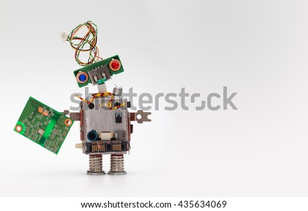 Robot with chip board. Computer accessories toy mechanism, funny head, electrical wire hairstyle, colorful blue red eyes. Copy space, gray background