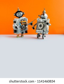 Robot electrician and two wheels serviceman robotic character ready for maintenance. Orange wall gray floor background. Copy space.