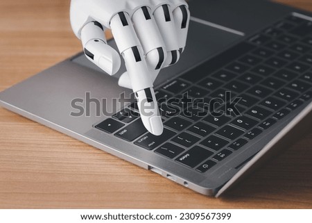 Robot hand finger typing or pressing enter on computer keyboard. Cyborg mechanical arm working with laptop. Artificial Intelligence futuristic design or chatbot concept.