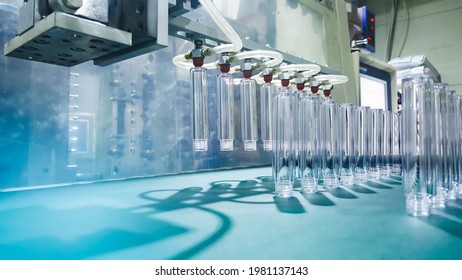 Robot Hand Holdind Lipstick Bottles. From Plastic Injection Molding Machine. Of The Product Manufacturing And Assembly Department. In The Plastic Parts Factory.