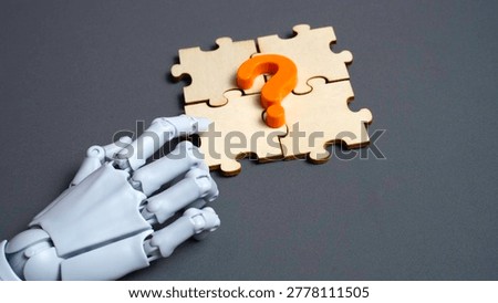 Robot hand pointing at orange question mark on wooden puzzle pieces for AI assistance and technology concept