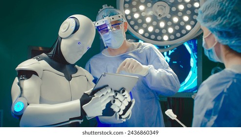 Robot holding digital tablet helps doctor to perform surgical operation in modern hospital. Teamwork of professional medical surgeons in operating room. Concept of modern medicine. - Powered by Shutterstock