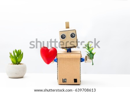 The robot holds a plant in its hand, and in the other hand a heart