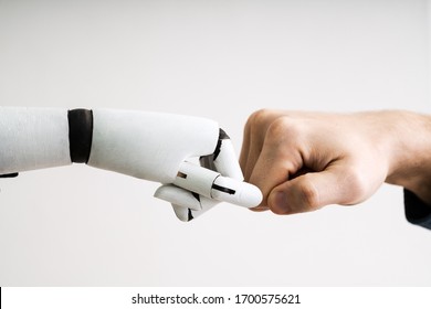 Robot And Human Hand Making Fist Bump On Grey Background