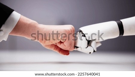 Robot And Human Hand Making Fist Bump On Grey Background