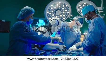 Robot performs operation on patient together with experienced specialists. Professional medical surgeons team work in operating room together with artificial intelligence.