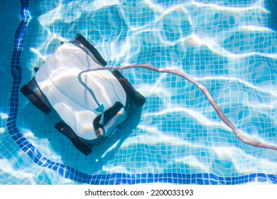 robot pool cleaner. Pool maintenance with automatic robot. cleaner the bottom of the pool and walls with a submersible robot. Summer pool cleaning robot before swimming. vacuum  cleaner - Shutterstock ID 2200033193