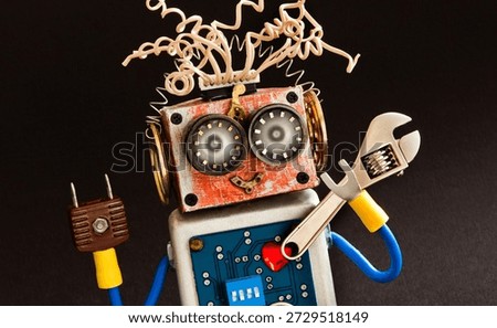 Robot serviceman with adjustable spanner. Close-up robotic toy. Maintenance concept. Black background.