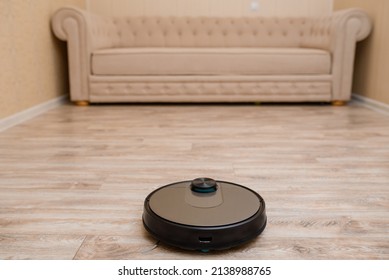 Robot vacuum cleaner is cleaning the floor in the living room.