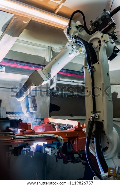 Robot is welding\
metal part in car\
factory\
