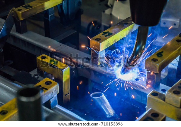 The robot is welding the work piece which\
covered with smoke and spark\
welding.