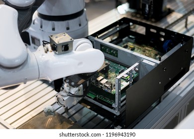 Robotic arm installing a computer chip in factory. Industrial and factory with machine technology 4.0 concept.