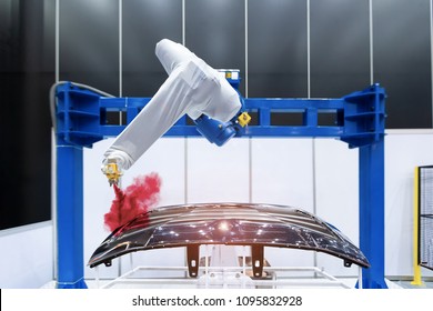 Robotic arm painting spray to the automotive part. High-technology manufacturing concept.