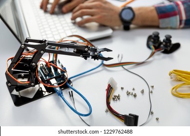 robotic engineering - technician programming robot arm on computer