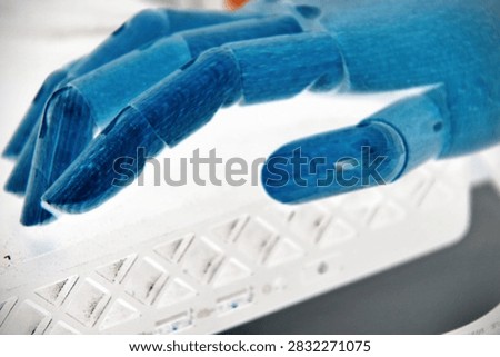 Robotic Hand Holding a Basic Computer Device