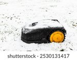 Robotic Lawn Mower. Robotic Lawn Mower on the grass covered with fist snow. Automatic robot lawnmower, first snow day.