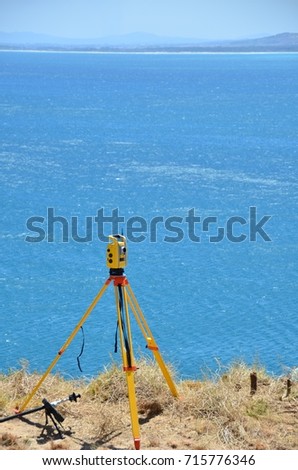Robotic total station instrument set up near the sea.