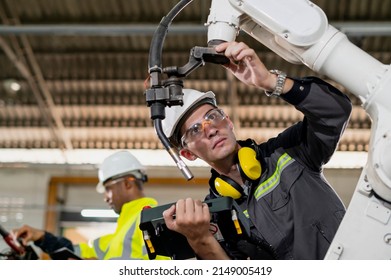 Robotics control engineers discussion and solve problems control panel of robot for setting programming for industrial robot arm controller in production plant factory - Powered by Shutterstock