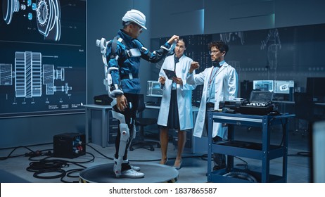 In Robotics Development Laboratory: Engineers And Scientists Work On A Bionics Exoskeleton Prototype With Person Testing It. Designing Wearable Exosuit To Help Disabled People, Warehouse Workers