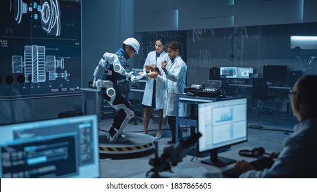 In Robotics Development Laboratory: Engineers And Scientists Work On A Bionics Exoskeleton Prototype With Person Testing It. Designing Wearable Exosuit To Help Disabled People, Warehouse Workers