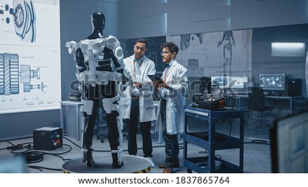 In Robotics Development Laboratory International Team of Engineers and Scientists Work on Robotics Exoskeleton Prototype. Designing Powered Exosuit to Help Disabled People Walk, Workers to Lift Goods