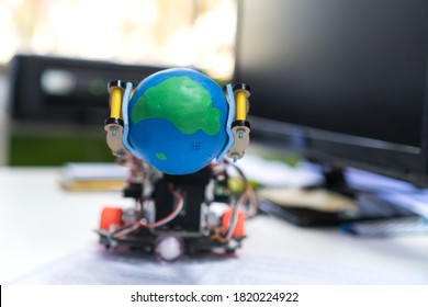 Robotics electronics in laboratory with computer, STEM Education for Learning for student science teachnology on Electronic board. Robot holding model globe by coding programming IOT innovation