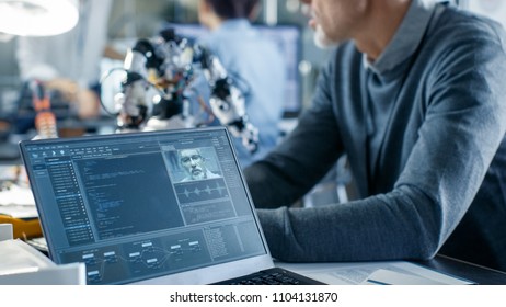 Robotics Engineer Manipulates Voice Controlled Robot, Laptop Screen Shows Speech and Face Recognition Software. In the Background Robotics Reseatch Center Laboratory. - Powered by Shutterstock