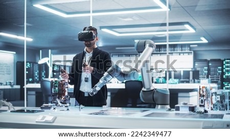 Robotics Engineer Operating a Futuristic Robotic Arm, Using a Virtual Reality Headset and Controllers to Perform Tasks. Work in Research and Development High Tech Facility Startup. 商業照片 © 