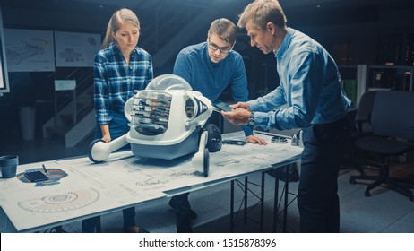 Robotics Engineering Facility Three Technical Engineers Talk and Work on a Wheeled Robot Prototype. In the Background High Tech Research Center with Screens Showing Industrial Design. Dark Shot - Shutterstock ID 1515878396