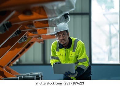 Robotics engineers inspect and maintain spare parts of industrial robot arm controller in production plant factory.