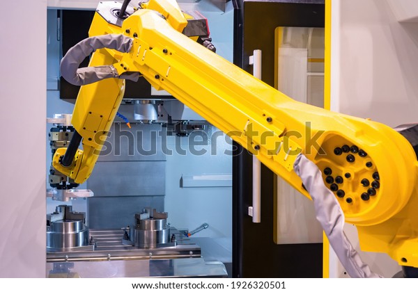 Robotics\
in production. Yellow arm manipulator in production. Manufacturing\
arm manipulator close up. Manufacturing using robotics. Modern\
equipment at the factory. Modern heavy\
industry.