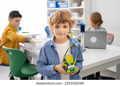 Robotics programming class. Children construct and code Robot. STEM education using constructor blocks and laptop, remote control joystick. Technology educational development for school kids. - Powered by Shutterstock