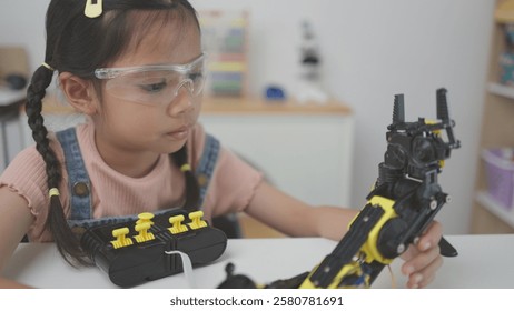 Robotics programming class. Children construct and code Robots. STEM education using constructor blocks and laptop, remote control joystick. Technology educational development for school kids