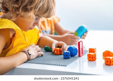 Robotics programming class. Preschool Children construct and code Robot. STEM education using constructor blocks and laptop, remote control joystick. Technology educational development for school kids
