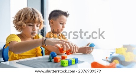 Robotics programming class. Preschool Children construct and code Robot. STEM education using constructor blocks and laptop, remote control joystick. Technology educational development for school kids
