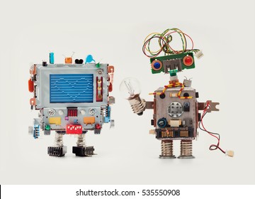 Robots in love. Funny man mechanism with monitor head, love heart abstract message on blue screen Woman robot green circuit face, electrical wire hairstyle, color blue red eyes, light bulb in hand. - Shutterstock ID 535550908