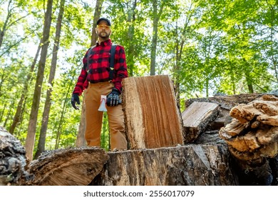 A robust young man wields an axe, skillfully cutting wood on his property. He clears the land while preparing a vital winter supply, turning effort into warmth for the cold months ahead.
