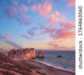 Rock Aphrodite near Petra tou Romiou in Cyprus, Paphos. Panoramic image of famous Cyprus landmark on romantic sunset with pink clouds.