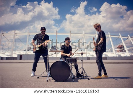 rock band in black clothing playing music on street