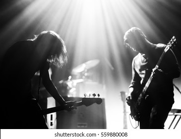 Rock Band On A Stage Playing In A Backlights, Black And White Silhouettes With The Beautiful Stage Lights