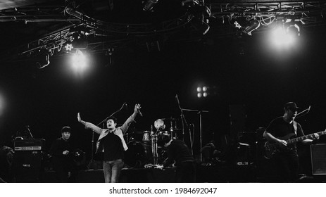 Rock Band Perform On Stage With Spotlight, Vocalist Raise Hand Up For Thank You The Audience In Concert At Club. Show Set Up.