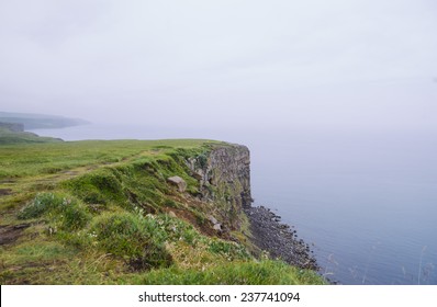 Rock Beach Cliff Edge On A Foggy Rainy Weather, Dark Ocean 