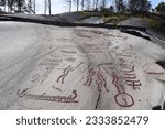 Rock carvings from the Bronze Age, which show a fight and boats and were painted with red paint, Tamumshede, Sweden