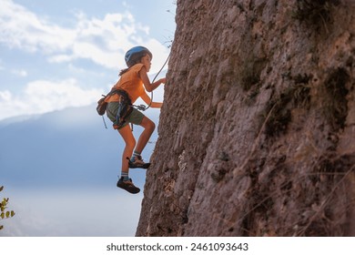 rock climber boy. child is practicing rock climbing. summer camp. sport in nature. cute teenager climbing on a rock with belay, sport people lifestyle concept