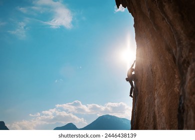 Rock climber climbing rock, man doing olympic sport on natural terrain, strength and endurance training, rock climber on the background of high mountains and blue sky - Powered by Shutterstock